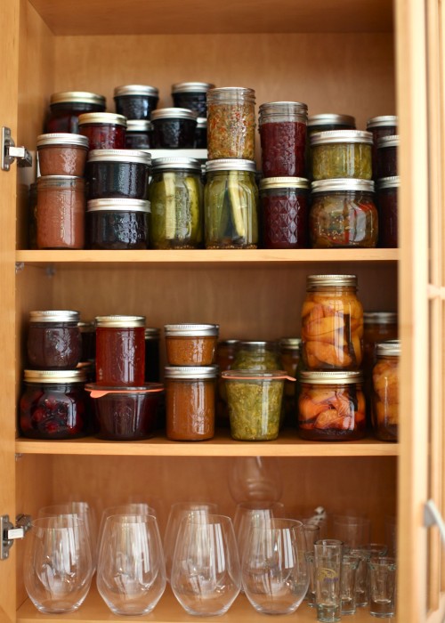 stocked pantry of summer preserves